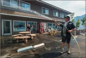  ?? PAUL KITAGAKI JR./SACRAMENTO BEE ?? Kevin Clark helps to protect his brother’s store as the Pawnee Fire burned and surrounded the area Sunday in Spring Valley in Lake County.