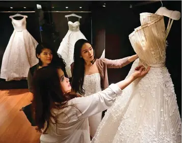  ?? GALIH COKRO/JAWA POS ?? SHARING: Pengunjung Let’s Talk About Love melihat gaun pengantin Tinara Bridal Boutique & Salon yang dipamerkan kemarin.