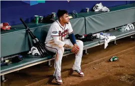  ?? CURTIS COMPTON / CCOMPTON@AJC.COM ?? Braves third baseman Johan Camargo sits in the dugout alone, the last to leave, watching the Dodgers celebrate their NLDS win.