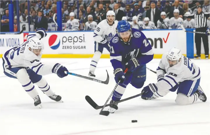  ?? KIM KLEMENT/USA TODAY SPORTS ?? Lightning centre Brayden Point skates between Maple Leafs winger Ilya Mikheyev, left, and defenceman Mark Giordano Sunday in Tampa Bay.