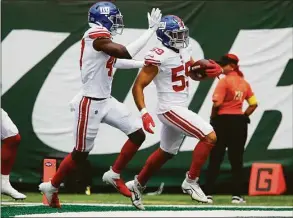  ?? John Munson / Associated Press ?? New York Giants linebacker Austin Calitro (59) runs in a touchdown in the first half of a preseason game against the New York Jets Sunday in East Rutherford, N.J.