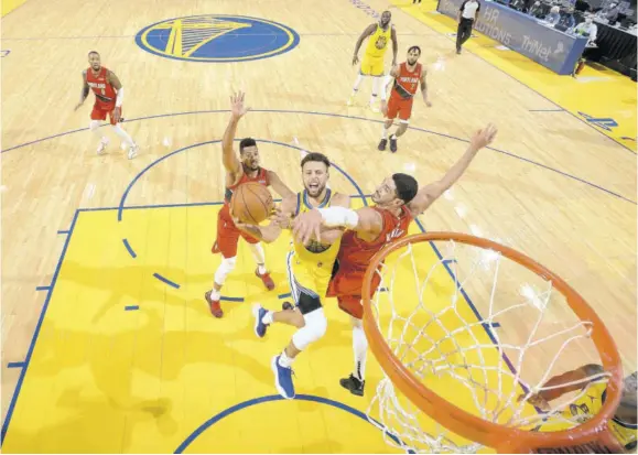  ?? (Photo: AFP) ?? Stephen Curry (yellow gear) of the Golden State Warriors drives to the basket during the game against the Portland Trail Blazers on Sunday at Chase Center in San Francisco, California.