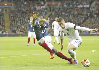  ??  ?? LONDON: England’s Ross Barkley fights for the ball against France’s Lassana Diarra during the internatio­nal friendly soccer match between England and France at Wembley Stadium in London, Tuesday. France is playing England at Wembley on Tuesday after...