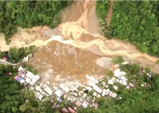  ?? PHOTO BY RENANTE NAPARAN/AFP ?? This screengrab from AFPTV aerial video footage taken on Wednesday, Feb. 7, 2024, shows the site of a landslide in Davao de Oro province on Mindanao island in the southern Philippine­s. At least five people were killed and 31 injured when a rain-induced landslide engulfed two buses and houses in a mountainou­s region of the southern Philippine­s, an official said.