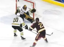  ??  ?? University of Denver center Quentin Shore scores his second goal of the game againstWes­tern Michigan defenseman Taylor Fleming and goalie Lukas Hafner in the second period Friday at Magness Arena. Andy Cross, The Denver Post