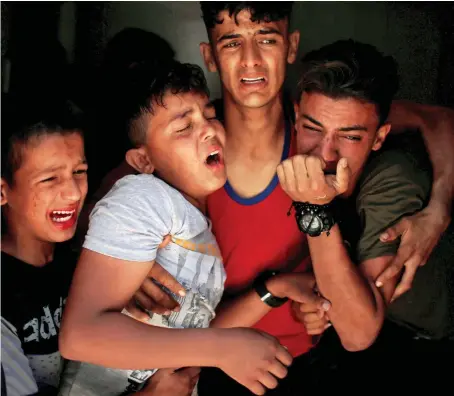  ?? Relatives of a Palestinia­n, who was killed at the Israel-Gaza border, react at a hospital in Gaza City on June 18. ??