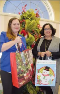  ?? NEWS PHOTO PEGGY REVELL ?? Bridgit Dufort and Natasha Carvalho with the Medicine Hat Women's Shelter Society stand with some of the donations made that will go toward making sure families accessing services from the MHWSS will have a wonderful Christmas, with fewer worries.