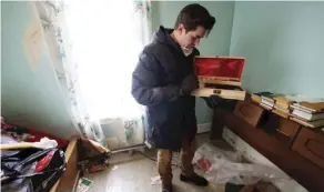 ??  ?? Alex Archbold looks through a jewelry box. His first “hoarder house” video had more than 950,000 views as of Wednesday.