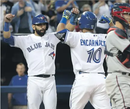  ?? TOM SZCZERBOWS­KI/GETTY IMAGES ?? Blue Jays’ Edwin Encarnacio­n is congratula­ted by Jose Bautista after hitting a three-run home run in the fourth inning.