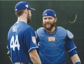  ?? Associated Press photo ?? Los Angeles Dodgers catcher Russell Martin talks to pitcher Rich Hill during a spring training baseball workout Wednesday in Glendale, Ariz.