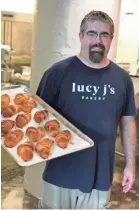  ??  ?? Josh Burgess, co-founder and executive director of the new Lucy J’s Bakery in Crosstown Concourse, pulls fresh croissants from the oven. JENNIFER CHANDLER/COMMERCIAL APPEAL