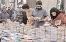  ?? -App ?? LAHORE
People selecting and purchasing old books from roadside setup.