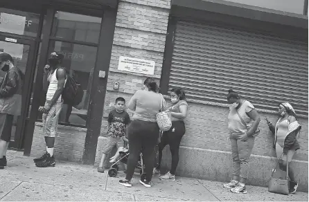  ?? SPENCER PLATT/ TNS ?? People wait in line for food assistance cards this month in Brooklyn, N. Y. Initial jobless claims in regular state programs fell by 99,000 to 1.31 million in the week ended July 4, Labor Department data showed Thursday.