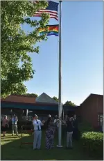  ?? PHOTO COURTESY OF NORTH PENN SCHOOL DISTRICT ?? North Penn School Board members and district and community officials raise a rainbow Pride flag.