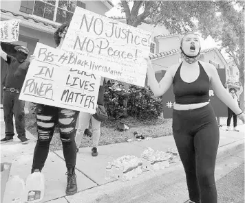  ?? STEPHEN M. DOWELL/ORLANDO SENTINEL PHOTOS ?? Protesters yell Friday outside the home of Derek Chauvin, the Minneapoli­s police officer videotaped kneeling on the neck of George Floyd before his death in Windermere.The video has sparked a national outcry.