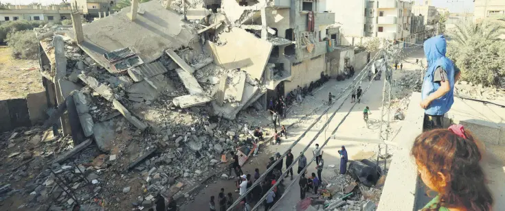  ?? ?? Young Palestinia­ns stand on a rooftoop overlookin­g the destructio­n in Rafah following overnight Israeli bombardmen­t of the area, in the southern Gaza Strip, Palestine, April 2, 2024.