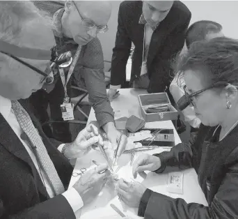  ??  ?? Dr. Thomas Spray, left, of the Children’s Hospital of Philadelph­ia, trains with help from Dr. Camille Hancock Friesen, chief pediatric cardiac surgeon at IWK Halifax hospital, as he performs the Norwood Procedure on a 3-D model newborn heart at the...