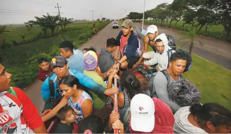  ?? AP ?? Central American migrants begin their morning trek as part of a thousands-strong caravan hoping to reach the US border, as they move away from Isla, Veracruz state, Mexico, yesterday.