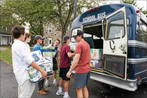  ?? SUBMITTED PHOTO ?? Members of The Hill School’s hockey team load donated supplies into a bus that took them to a container that will be shipped to hurricane victims in Puerto Rico.