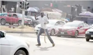  ?? PHOTO: Ikechukwu Ibe ?? A volunteer controls the traffic along Solomon Lar Way in Jabi Abuja on Thursday