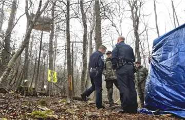  ??  ?? State and local police, who are waiting to arrest Theresa “Red” Terry, stand near her platform in Roanoke County, Virginia, where she is protesting the approach of the Mountain Valley Pipeline along with her daughter, Theresa.