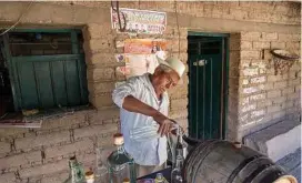  ??  ?? Santo Martinez pours mezcal in front of his mezcal distillery outside of Mitla. Mezcal is made from agave.