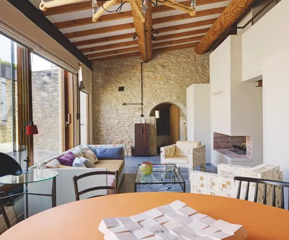  ??  ?? SITTING ROOMRabih built a Modernist-inspired fire surround (above left), with stairs to the upper level within the artificial chimney breast. ENTRANCETh­e exterior walls (far left) have been restored and great care was taken to retain the character and patina of the stone. COURTYARDT­his sheltered breakfast spot (left) features tables and stools made by a local craftsman, using recycled metal cans finished with a silver birch paint effect. DINING AREAMore formal meals are enjoyed at the vintage Peter Hvidt dining table, set at one end of the sitting room (above). | | august 2018 79 H&amp;G