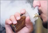  ?? Frank Augstein / Associated Press ?? Legislatio­n approved by the General Assembly’s Finance Committee on Monday would ban the sell of flavored vaping and e-cigarettes in Connecticu­t, aligning the law with New York, Massachuse­tts and Rhode Island.