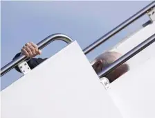  ?? Ap pHOTOS ?? EARLY TRIP: President Biden stumbles while boarding Air Force One on Friday at Joint Base Andrews, but manages to hold onto the railing, below left.