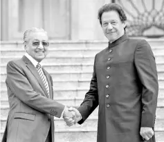  ??  ?? Prime Minister Tun Dr Mahathir Mohamad (left) shakes hand with his counterpar­t Imran Khan during an official welcome at Dataran Perdana yesterday. - Bernama photo