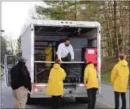  ?? COURTESY OF WHITE HORSE VILLAGE ?? Chris Stewart, in the truck, gives team members instructio­ns for the day’s meal delivery service.