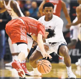  ?? Jessica Hill / Associated Press ?? Boston University's Javante McCoy, left, runs into UConn’s Alterique Gilbert and loses control of the ball during the first half Sunday.