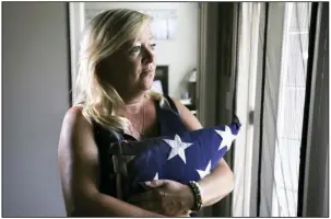  ?? (NWA Democrat-Gazette/Charlie Kaijo) ?? Gold Star mother Jill Stephenson holds her son’s casket flag Aug. 23 at her home in Bentonvill­e. Stephenson’s son was killed while serving in Afghanista­n in 2009.