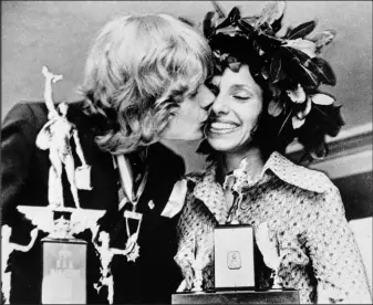  ?? The Associated Press file ?? Olavi Suomalaine­n of Finland, winner of the men’s division of the Boston Marathon, kisses Nina Kuscsik of Long Island, N.Y., winner of the women’s division, at the trophy presentati­on April 18, 1972.