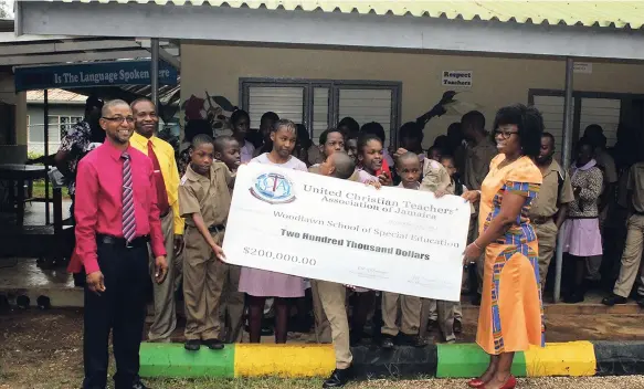  ??  ?? Acting principal of the Woodlawn School of Special Education Christophe­r Turner (left), and students of the institutio­n receive a cheque of $200,000 from UCTAJ president Adesuwa Omoregie.