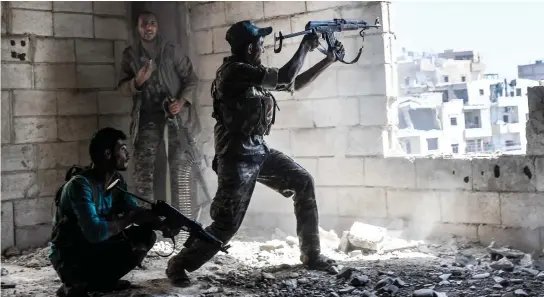  ??  ?? Members of anti-Assad forces fire at their rival militants in Raqqa. (File photo/AFP)