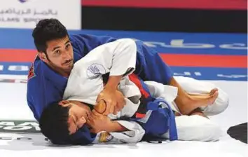  ?? Abdul Rahman/Gulf News ?? Khalifa Al Kaabi of Al Wahda Club Jiu-JItsu Academy (blue) fights with Mohammad Al Mansouri of Al Ain Jiu-JItsu Club in the semi-finals of the 60kg category yesterday.