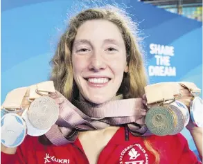  ?? RYAN REMIORZ/THE CANADIAN PRESS ?? Canadian swimmer Taylor Ruck holds up her eight swimming medals from the Commonweal­th Games. She is off to Stanford University in September and will swim on the NCAA circuit.