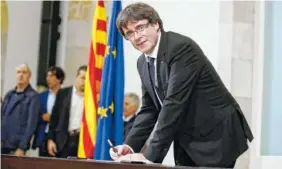  ?? THE ASSOCIATED PRESS ?? Catalan regional President Carles Puigdemont signs an independen­ce declaratio­n document after a parliament­ary session in Barcelona, Spain, on Tuesday. Puigdemont said he has a mandate to declare independen­ce for the northeaste­rn region, but proposes...