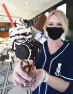  ?? STAFF PHOTO BY MATT HAMILTON ?? Melissa Cain holds a “Chattanoog­a Shoe Shine Boy Cookies & Cream” milkshake at the Ooltewah Whistle Stop on Thursday.