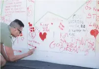  ?? (Hannah Mckay/Reuters) ?? PEOPLE WRITE get well messages on a wall at a fanzone in Copenhagan after Denmark’s Christian Eriksen collapsed on the pitch during his side’s Euro 2020 match with Finland.