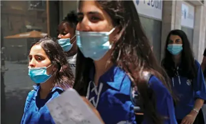  ?? Photograph: Menahem Kahana/AFP/Getty ?? Young Israelis wearing protective masks in the centre of Jerusalem.