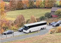  ?? Associated Press ?? A tour bus shares a narrow road with cars outside a private property in an undated photo in Pomfret, Vermont.