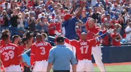  ?? FRED THORNHILL, THE CANADIAN PRESS ?? Steve Pearce, right, high-fives Marcus Stroman, after his walkoff grand slam Sunday. The Jays trailed 10-4 going into the bottom of the ninth, winning 11-10.