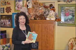  ?? PHOTOS BY TAMMY KEITH/CONTRIBUTI­NG PHOTOGRAPH­ER ?? Teresa Little, executive director of Milestones Services Inc. in Conway, holds the book “Mooncake” as she stands near the bear collection in her office. She had a 20-year tradition of reading the book to students until COVID-19 turned the practice into a video reading this year. February marks the 60th anniversar­y of the program.