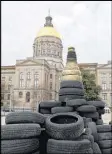  ?? BOB ANDRES / AJC ?? Georgians held a rally across from the Capitol, building a replica of the state capitol using scrap tires that they dubbed the “Scrapitol.” They were advocating for legislatio­n forcing the state to stop raiding funds meant for tire dump and driver’s ed...