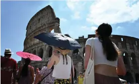  ?? Photograph: Alberto Pizzoli/AFP/Getty Images ?? Tourists shelter from the sun near the Colosseum in Rome, where temperatur­es are expected to hit 40C on Tueday.