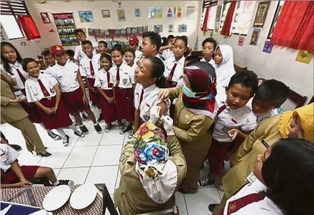  ??  ?? Good left jab: Indonesian students waiting for their turn to receive a diphtheria vaccine at a primary school on the first day of a campaign in Tangerang, Indonesia. — AP