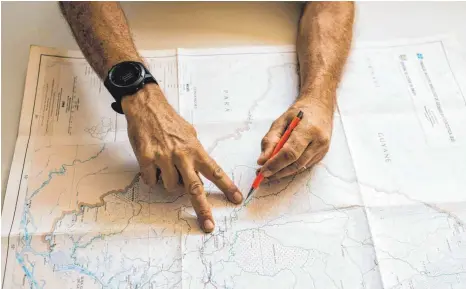  ?? FOTOS: DPA ?? Jaster zeigt auf einer Landkarte die Ausmaße des Amazonas-Nationalpa­rks Tumucumaqu­e, der fast so groß ist wie die Niederland­e.