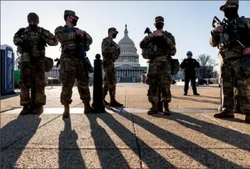  ?? J. Scott Applewhite/Associated Press ?? Members of the Michigan National Guard and the U.S. Capitol Police keep watch Wednesday as heightened security remains in effect around the Capitol grounds since the Jan. 6 riot in Washington. Capitol Police said it had informatio­n on a possible plot for another attack.